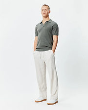 Mens Devon Knit Polo in dark green, featuring a textured knit fabric, classic fit, and a small white embroidered Psycho Bunny skull logo on the left chest.