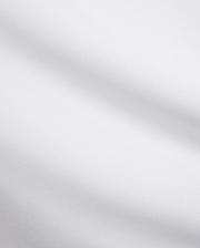 Mens Edwin Sport Polo, a premium white pique fabric, showcasing its refined textured weave. This high-quality material is characteristic of Psycho Bunny's sophisticated streetwear.