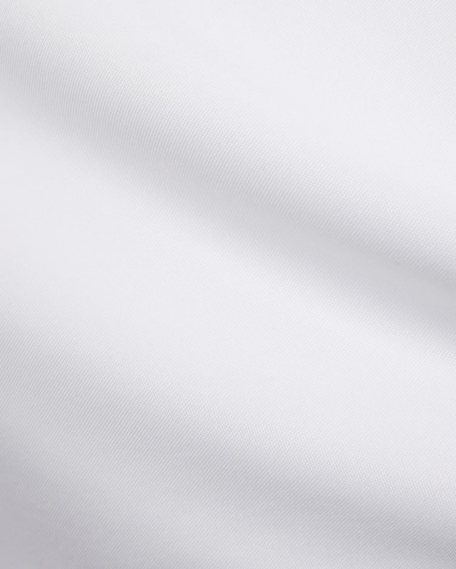 Mens Edwin Sport Polo, a premium white pique fabric, showcasing its refined textured weave. This high-quality material is characteristic of Psycho Bunny's sophisticated streetwear.