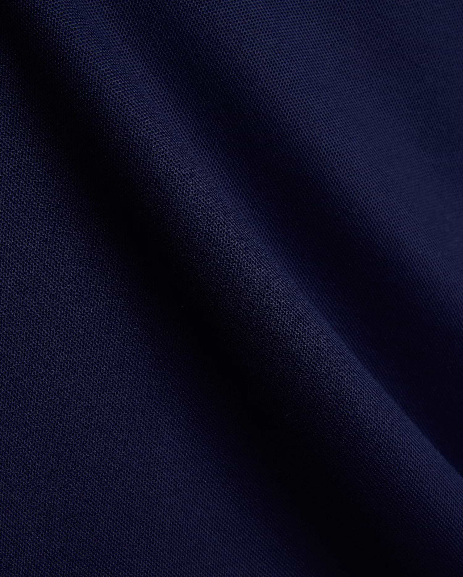 Mens Holden Pique Polo fabric in a luxurious, deep navy blue, showcasing the signature textured pique weave with subtle folds, embodying Psycho Bunny's premium menswear and refined streetwear aesthetic. (6)
