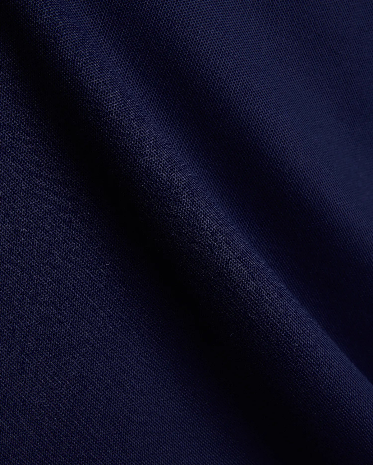 Mens Holden Pique Polo fabric in a luxurious, deep navy blue, showcasing the signature textured pique weave with subtle folds, embodying Psycho Bunny's premium menswear and refined streetwear aesthetic. (6)