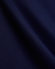 Mens Holden Pique Polo fabric in a luxurious, deep navy blue, showcasing the signature textured pique weave with subtle folds, embodying Psycho Bunny's premium menswear and refined streetwear aesthetic. (6)