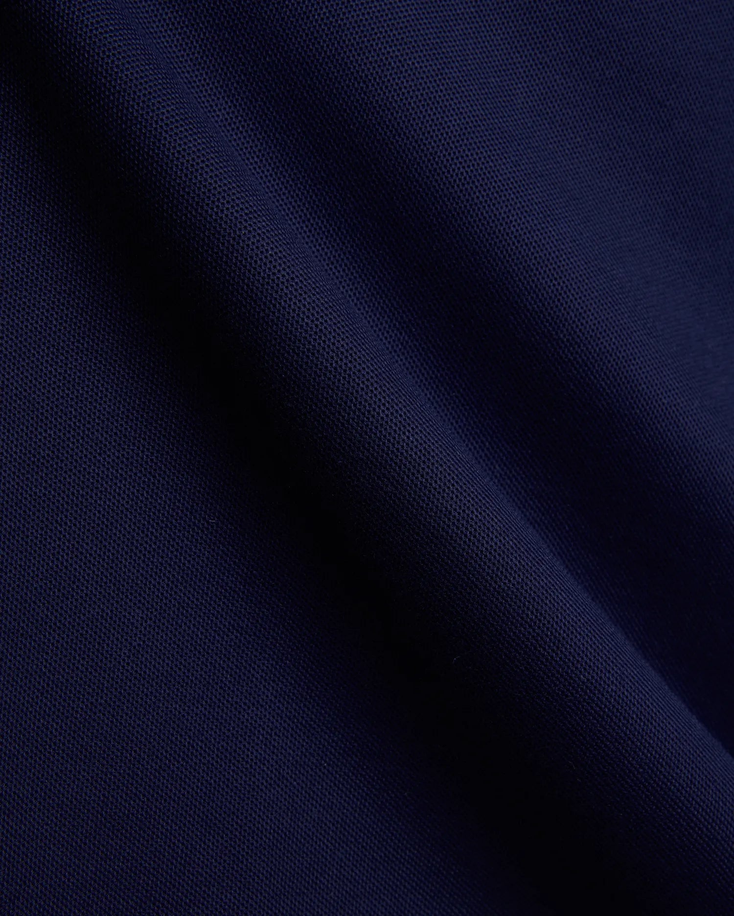 Mens Holden Pique Polo fabric in a luxurious, deep navy blue, showcasing the signature textured pique weave with subtle folds, embodying Psycho Bunny's premium menswear and refined streetwear aesthetic. (6)