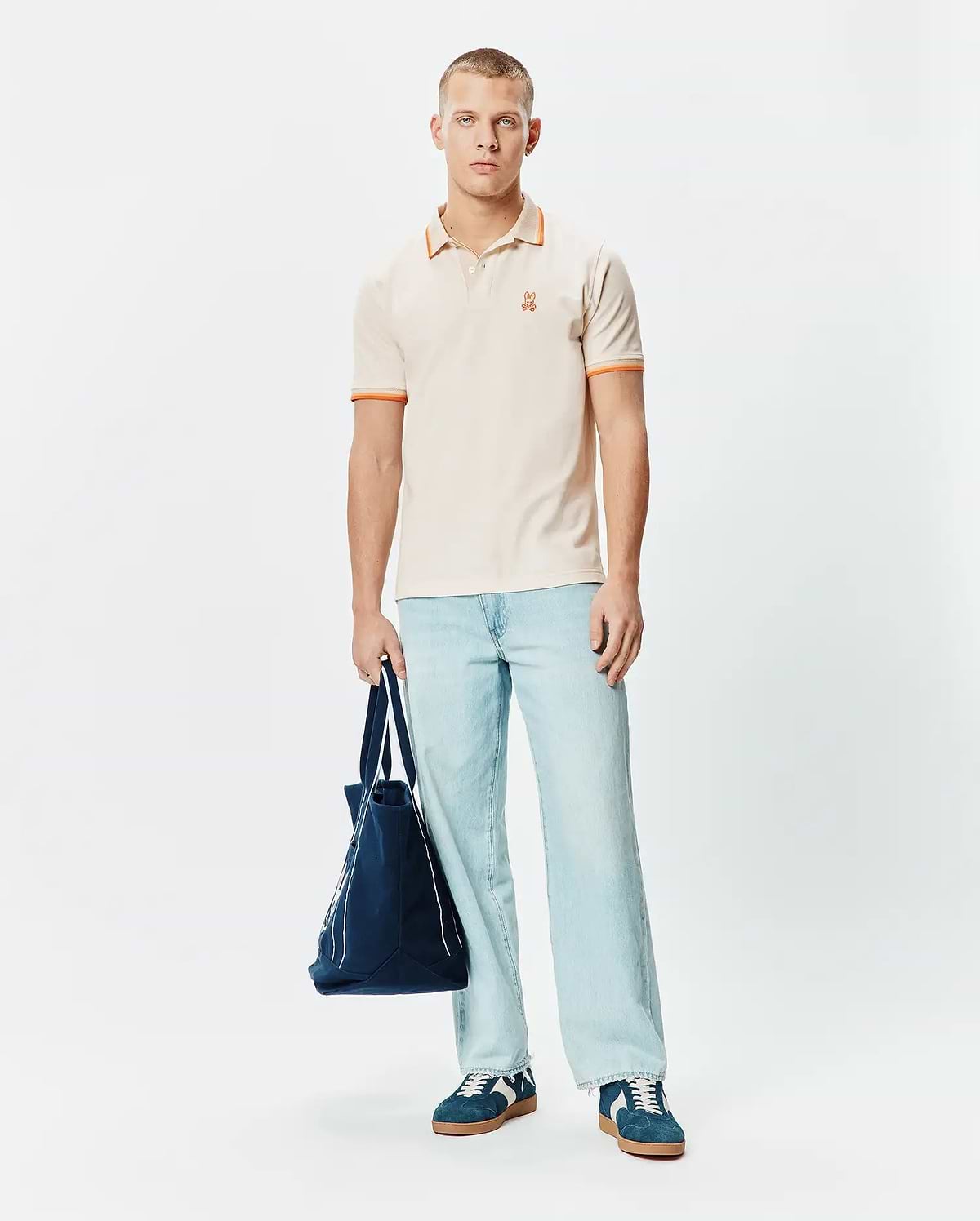 Mens Holden Pique Polo in cream, featuring a classic fit, orange tipped collar and cuffs, and a small embroidered orange Psycho Bunny skull logo on the left chest. (4)