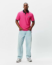 Mens Nate Pique Polo in vibrant pink, featuring a classic fit, black ribbed collar and cuffs with white tipping, and a small embroidered Psycho Bunny skull logo on the left chest. (4)