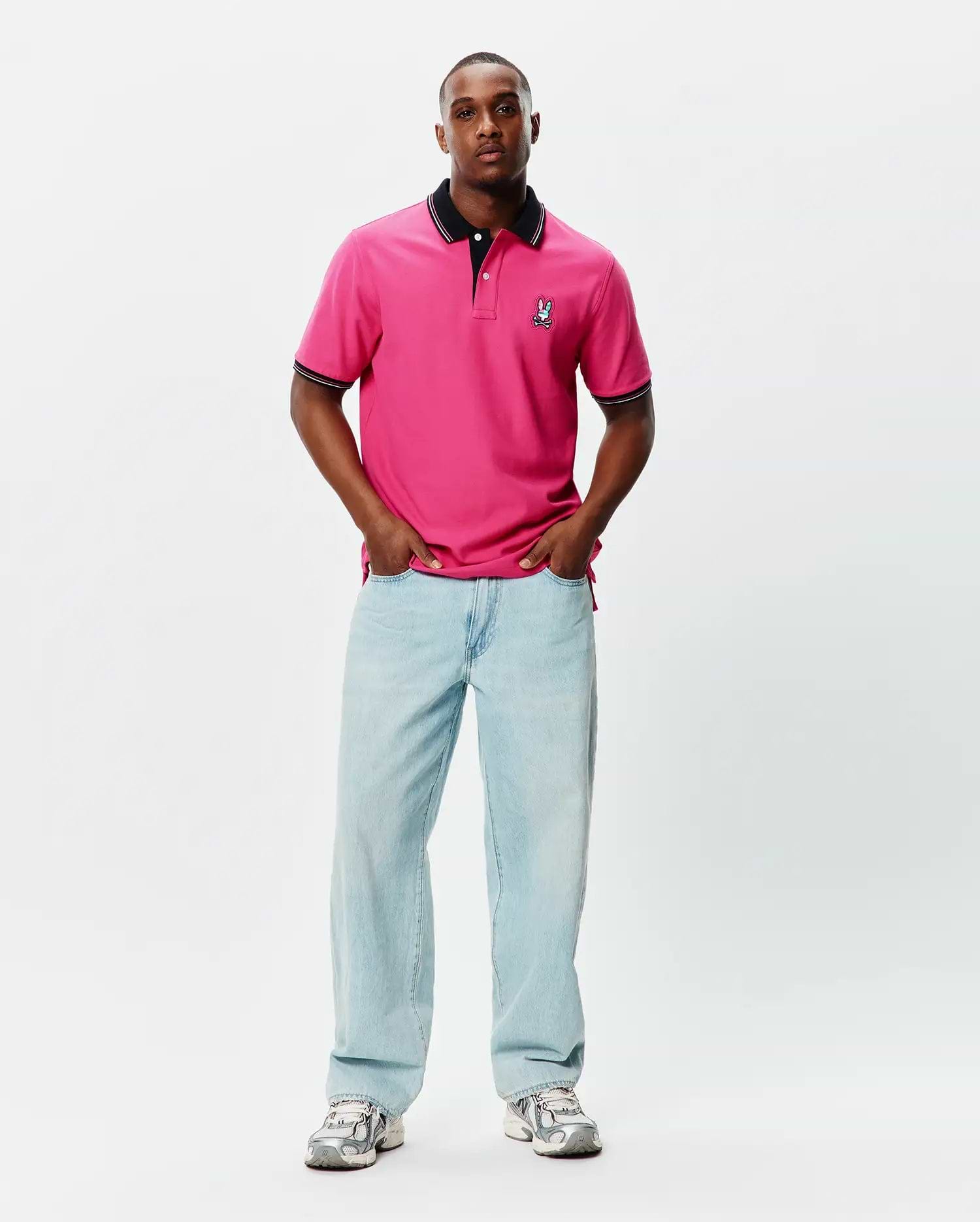 Mens Nate Pique Polo in vibrant pink, featuring a classic fit, black ribbed collar and cuffs with white tipping, and a small embroidered Psycho Bunny skull logo on the left chest. (4)