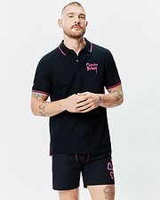 Mens Duncan Pique Polo, black with pink collar and cuff tipping. Features an embroidered pink Psycho Bunny chest logo, small sleeve bunny skull, and pink side vents. Classic fit.
