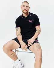 Mens Duncan Pique Polo, black with pink striped collar and sleeve cuffs, featuring an embroidered pink Psycho Bunny script logo on the left chest, in classic fit pique fabric.