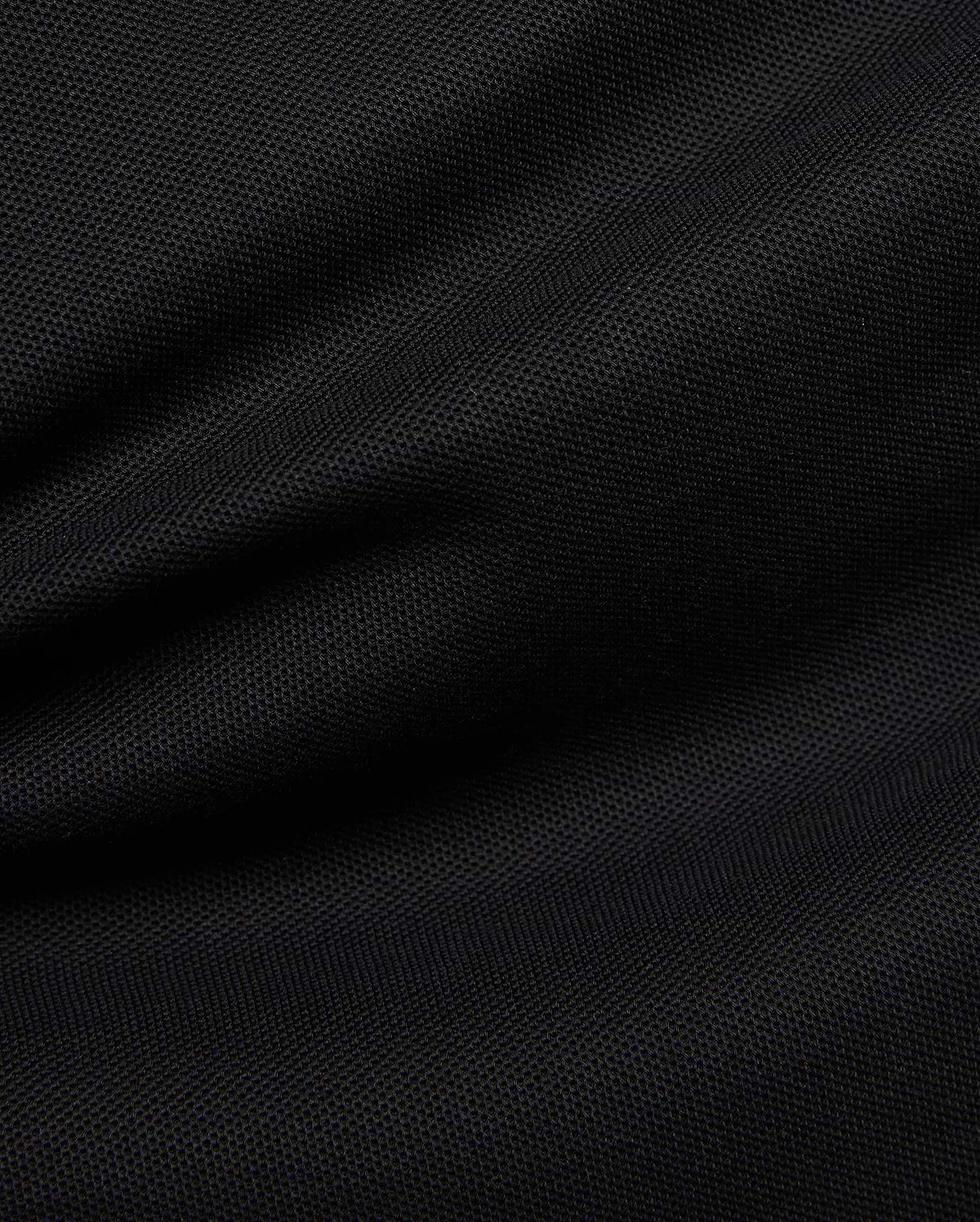 Premium black Mens Duncan Pique Polo, showcasing its breathable, classic pique fabric with a distinct textured weave and subtle folds, perfect for refined streetwear.