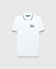 Mens Duncan Pique Polo, white classic fit pique polo with black striped collar and cuffs, featuring a distressed black Psycho Bunny text logo embroidered on the left chest and green neck tape.
