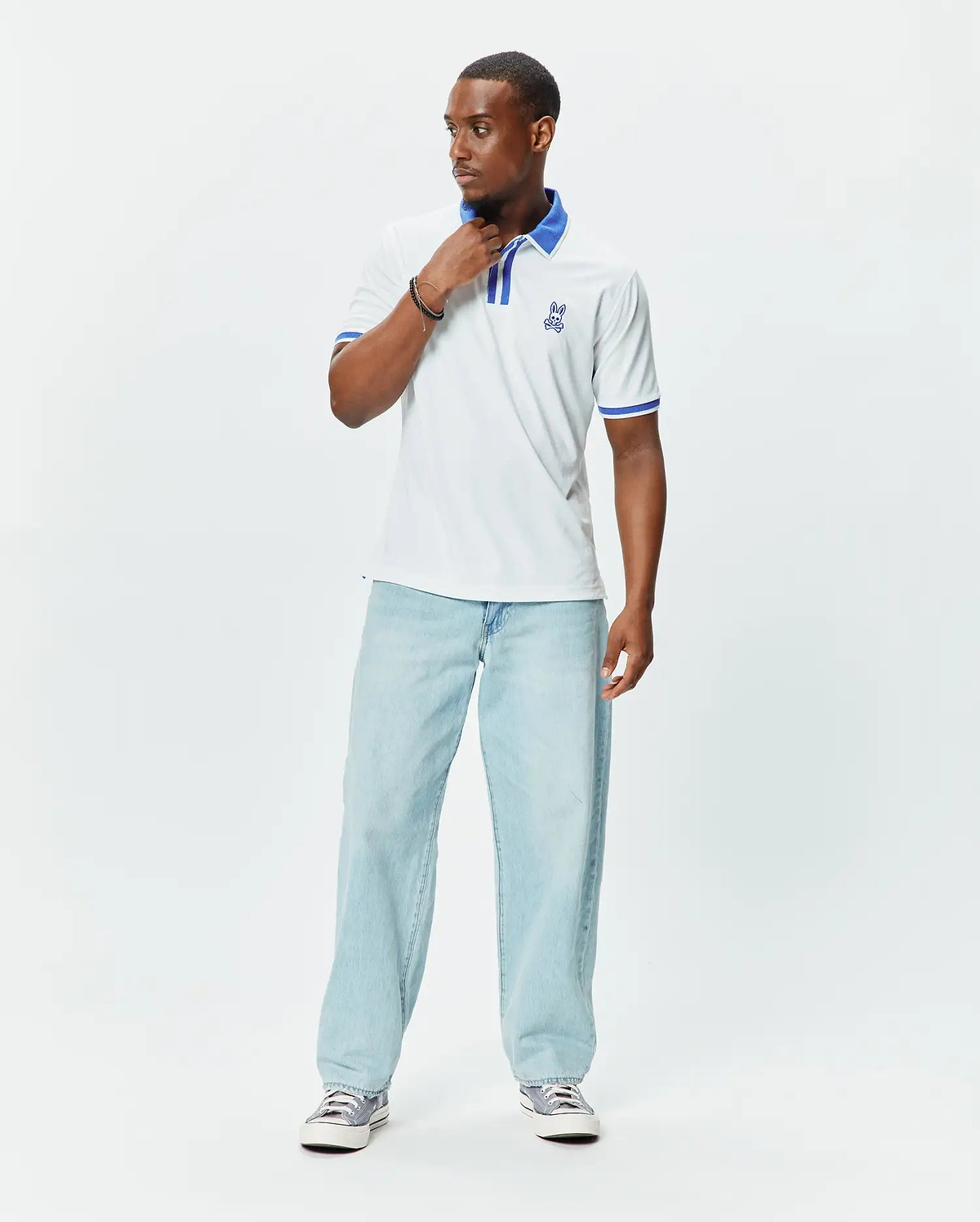 Mens Ridley Pique Polo in white pique, featuring a classic fit, blue striped collar and cuffs, and an embroidered blue Psycho Bunny skull logo on the left chest. (3)