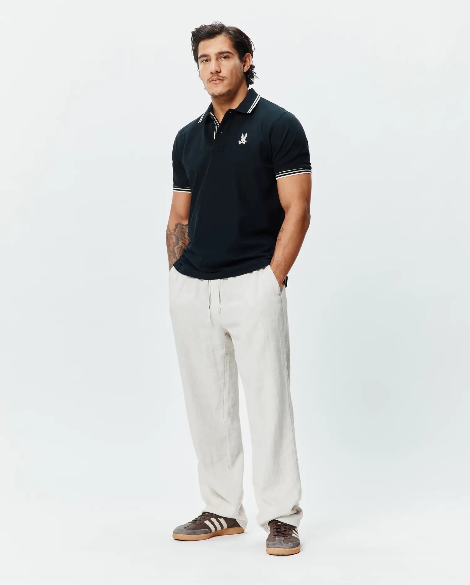 Mens Brad Pique Polo in navy, featuring a classic fit, pique texture, white tipped collar and cuffs, and a small embroidered white Psycho Bunny skull logo on the left chest. (4)