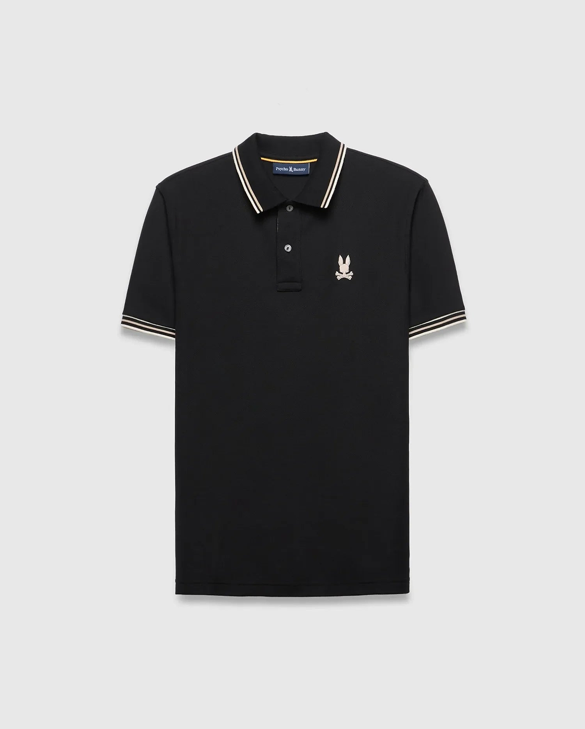 Mens Brad Pique Polo, black classic fit with white and gold striped collar and cuffs, featuring a small embroidered light pink/cream Psycho Bunny skull logo on the left chest. (5)