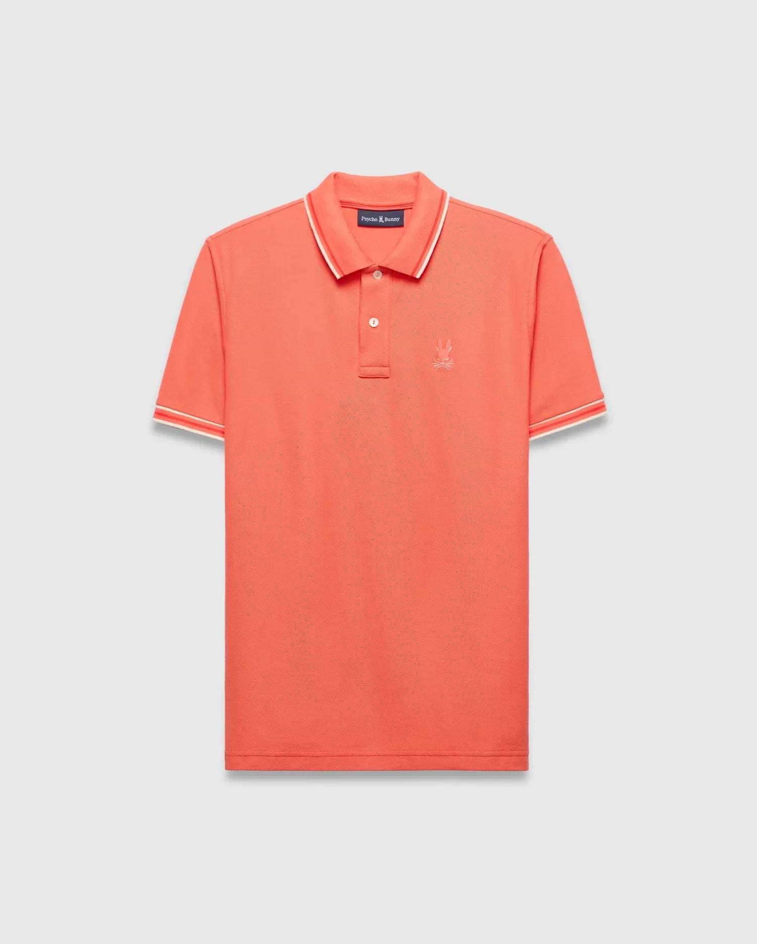 Vibrant Coral Mens Brad Pique Polo, a classic fit premium menswear piece with textured pique fabric, white and red tipped collar and cuffs, and a small embroidered Psycho Bunny skull logo on the left chest. (5)