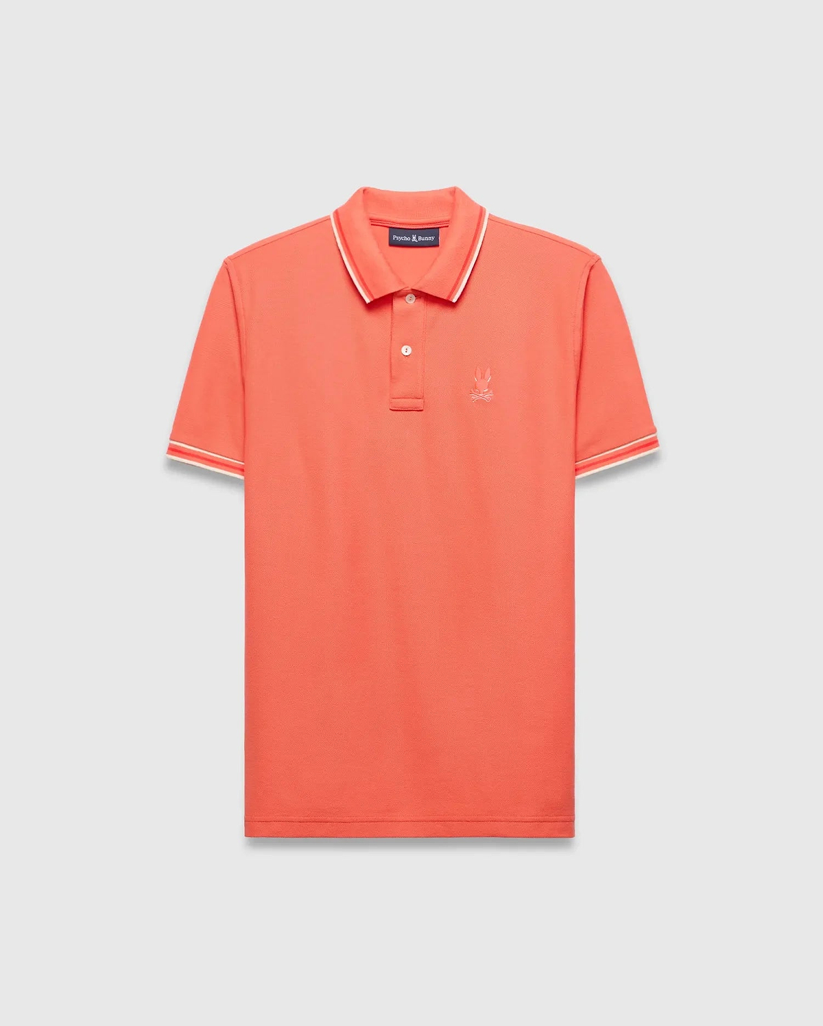 Vibrant Coral Mens Brad Pique Polo, a classic fit premium menswear piece with textured pique fabric, white and red tipped collar and cuffs, and a small embroidered Psycho Bunny skull logo on the left chest. (5)