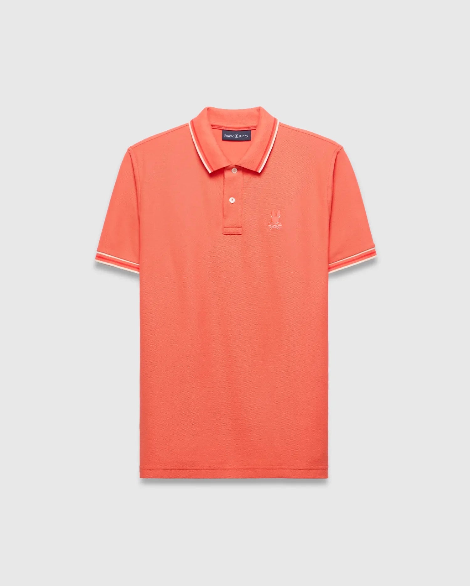 Vibrant Coral Mens Brad Pique Polo, a classic fit premium menswear piece with textured pique fabric, white and red tipped collar and cuffs, and a small embroidered Psycho Bunny skull logo on the left chest. (5)