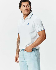 Mens Brad Pique Polo: White classic fit pique polo with blue tipped collar and cuffs, featuring a small embroidered blue Psycho Bunny skull logo on the left chest.