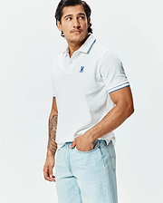 Mens Brad Pique Polo: White classic fit pique polo with blue tipped collar and cuffs, featuring a small embroidered blue Psycho Bunny skull logo on the left chest.