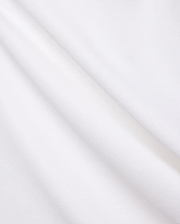 Crisp White Mens Brad Pique Polo fabric, highlighting its distinctive textured pique weave, soft, luxurious feel, and elegant folds, embodying premium Psycho Bunny menswear.