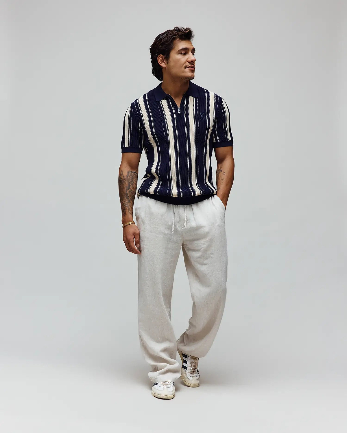 Mens Cliff Knit Zip Polo, a classic fit navy and cream striped knit polo with a half-zip placket and small embroidered Psycho Bunny skull logo on the left chest. (4)