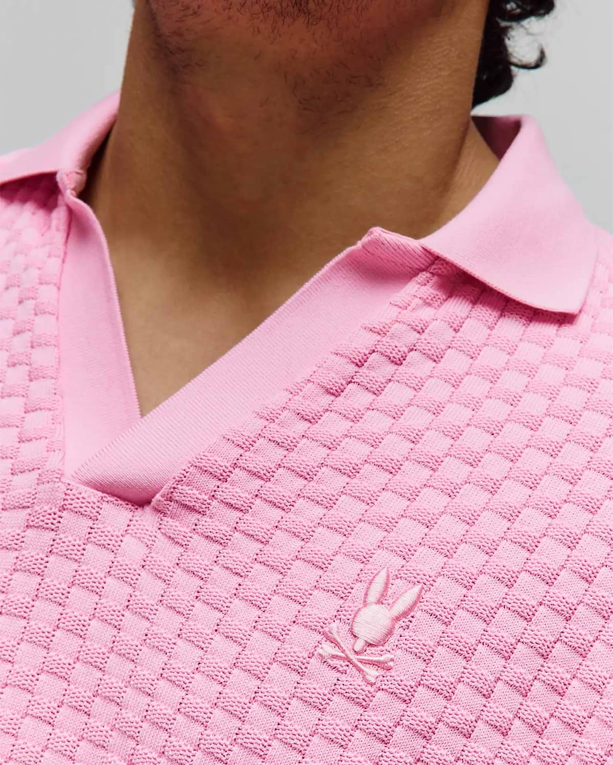 Mens Garen Knit Polo. Vibrant pink knit polo shirt with a distinctive basketweave texture, a ribbed spread collar, and a small, tonal embroidered Psycho Bunny skull logo on the left chest. (3)