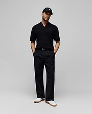 Mens Garen Knit Polo in black, featuring a textured knit fabric, open collar, and a small dark blue embroidered Psycho Bunny skull logo on the left chest for a classic fit. (3)