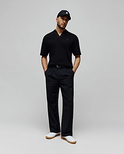Mens Garen Knit Polo in black, featuring a textured knit fabric, open collar, and a small dark blue embroidered Psycho Bunny skull logo on the left chest for a classic fit. (3)