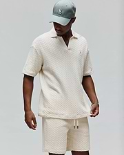 Mens Garen Knit Polo in cream, featuring a relaxed fit, textured basketweave knit fabric, an open resort collar, and a small embroidered Psycho Bunny skull logo on the left chest. (3)