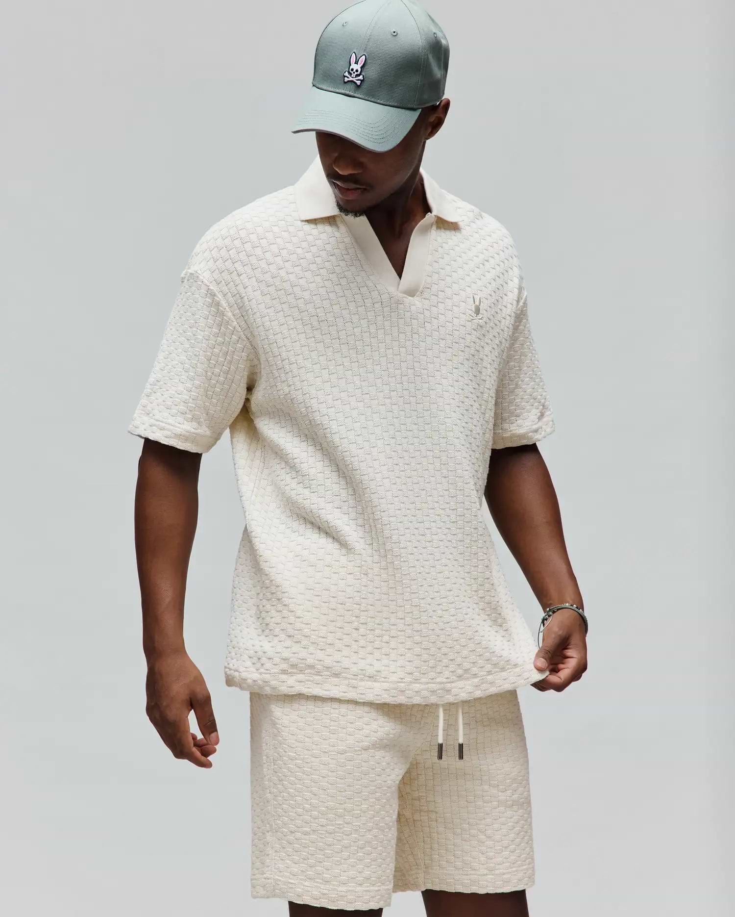 Mens Garen Knit Polo in cream, featuring a relaxed fit, textured basketweave knit fabric, an open resort collar, and a small embroidered Psycho Bunny skull logo on the left chest. (3)