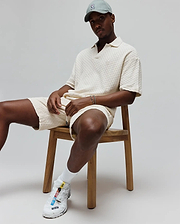 Mens Garen Knit Polo in cream, featuring a relaxed fit and a distinctive textured basketweave knit fabric, with a small, tone-on-tone embroidered Psycho Bunny skull logo on the left chest. (1)