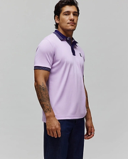 Mens Kenyon Pique Polo, a classic fit lavender pique polo with navy collar, placket, and white-striped ribbed cuffs, featuring a small embroidered Psycho Bunny skull logo on the left chest.