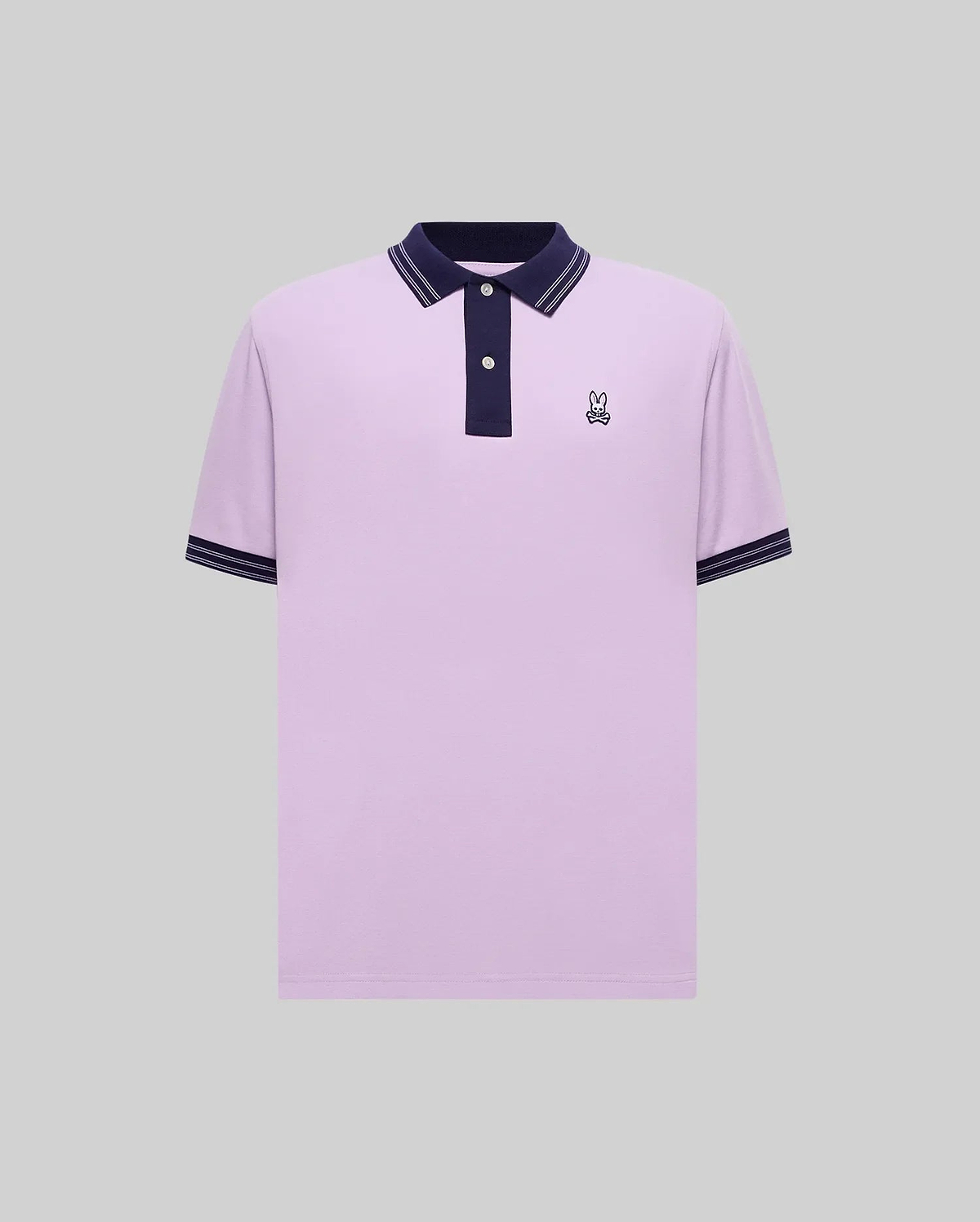 Mens Kenyon Pique Polo, a lavender classic fit pique polo with navy collar, two-button placket, navy cuffs with white stripes, and a small embroidered Psycho Bunny skull logo on the left chest.