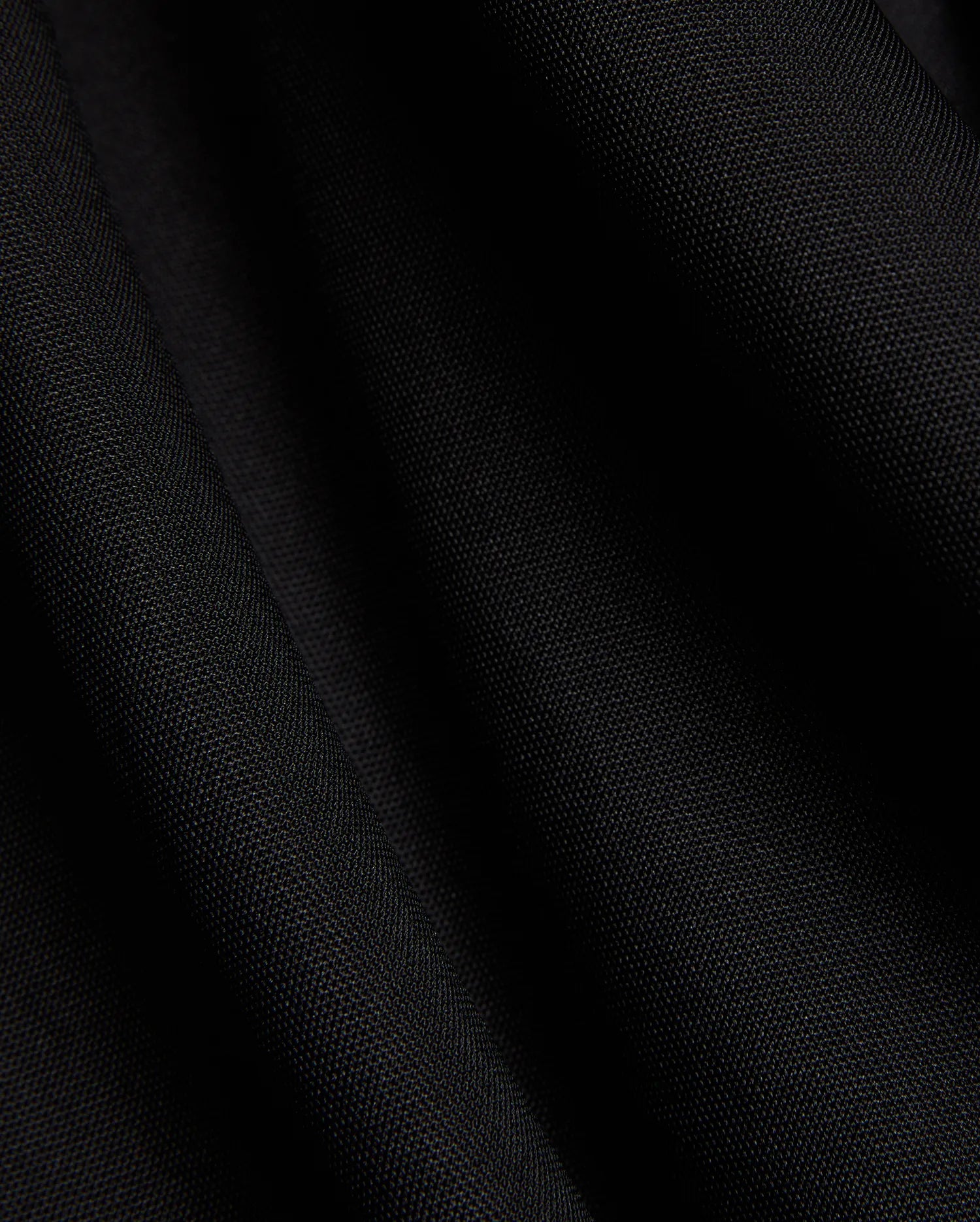 Mens Odin Zip Sport Polo in a rich black, featuring a visible premium pique knit fabric texture, characteristic of Psycho Bunny's refined streetwear style.