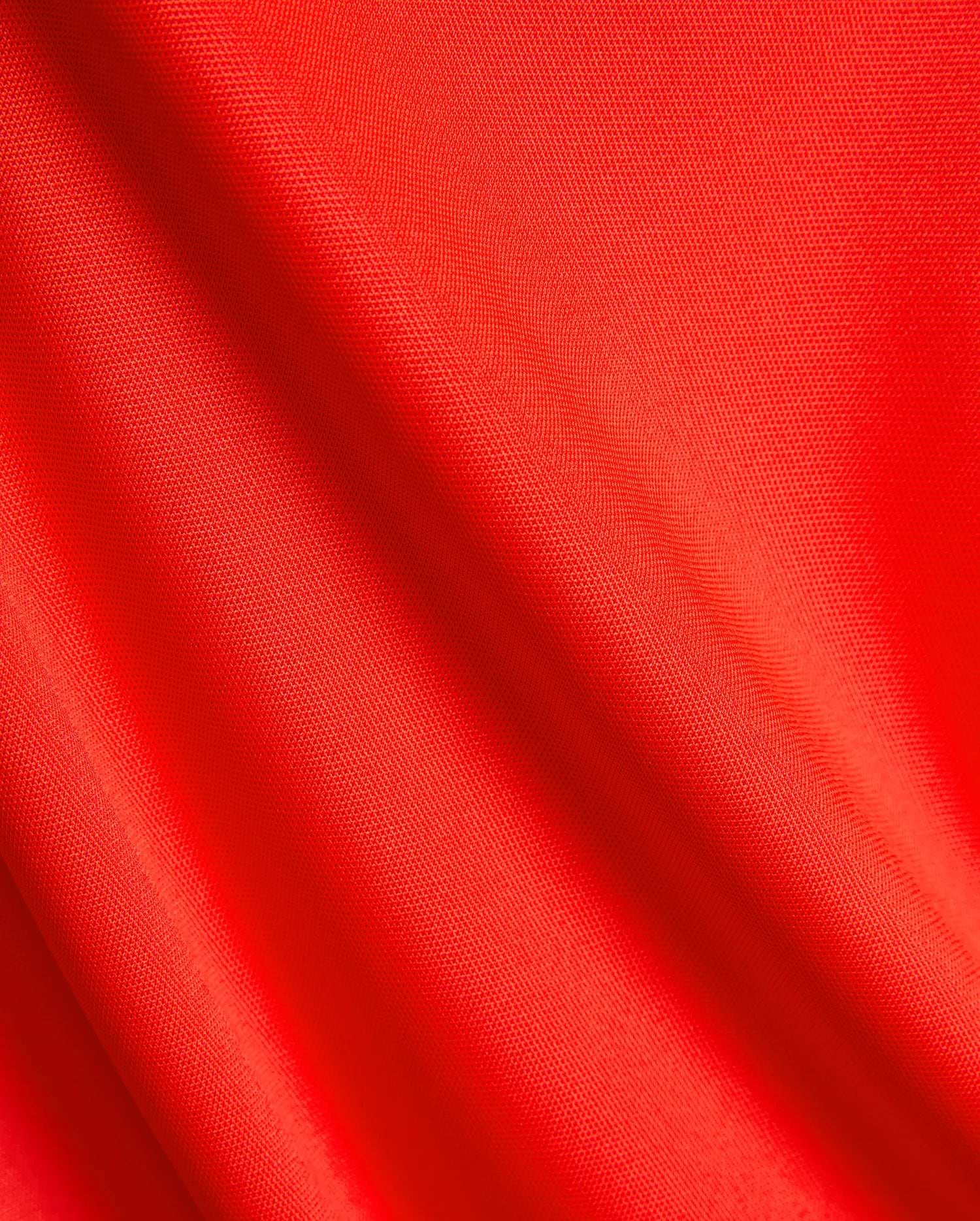 Vibrant red pique knit fabric for the Mens Odin Zip Sport Polo, a premium Psycho Bunny piece, showcasing its distinctive textured weave, ideal for refined streetwear.