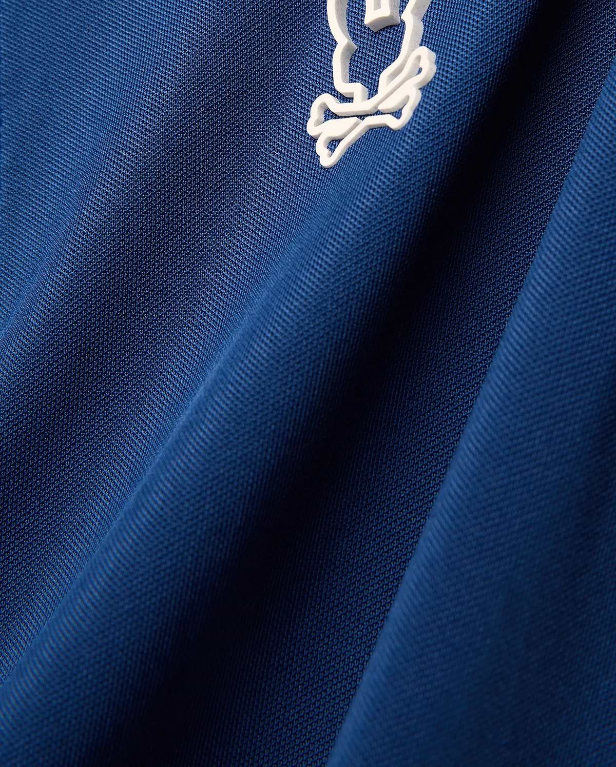 Mens Odin Zip Sport Polo in royal blue pique knit fabric, featuring a small white embroidered iconic Psycho Bunny skull logo on the chest.