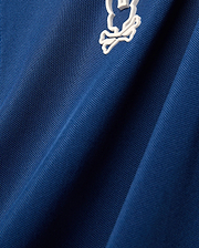 Mens Odin Zip Sport Polo in royal blue pique knit fabric, featuring a small white embroidered iconic Psycho Bunny skull logo on the chest.