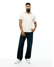 Mens Timmy Interlock Polo, a classic fit cream interlock polo with navy and white striped collar and cuffs, featuring a small embroidered Psycho Bunny skull logo on the left chest.