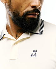 Cream Mens Timmy Interlock Polo, classic fit, smooth interlock knit, with a navy blue striped collar and an embroidered Psycho Bunny skull logo on the left chest.