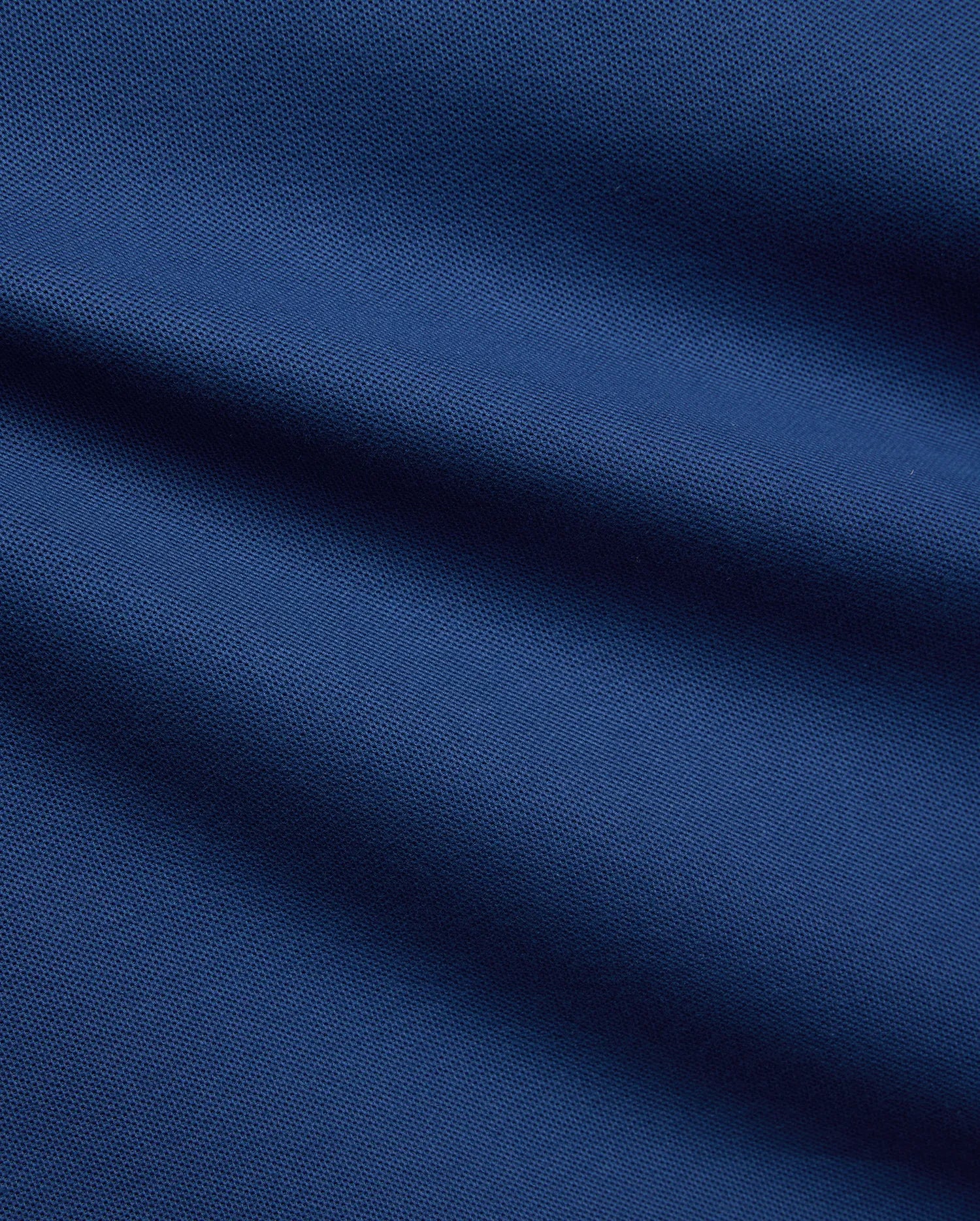 Mens Stan Pique Polo in a rich, deep blue, highlighting the classic textured pique weave, a premium and breathable fabric from Psycho Bunny menswear. (6)