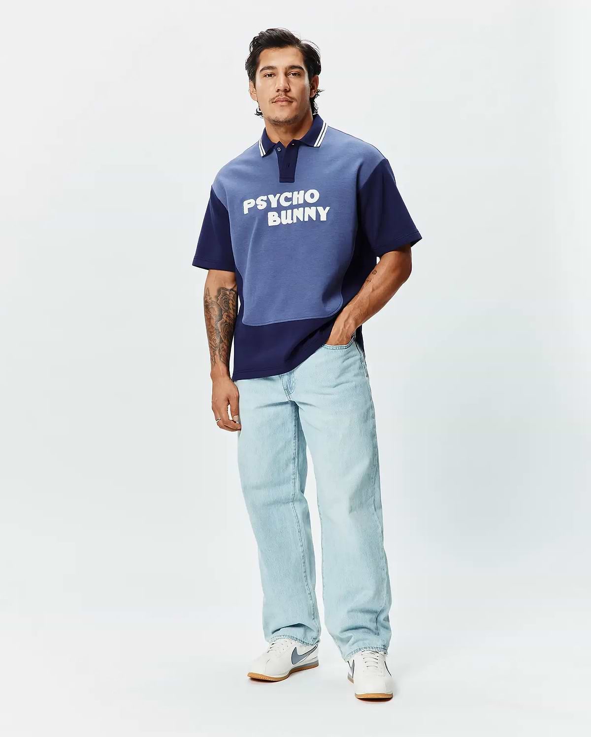 Mens Kelly Oversized Polo, a two-tone blue color block jersey polo with an oversized fit, featuring white collar stripes and a large white PSYCHO BUNNY text logo across the chest. (4)