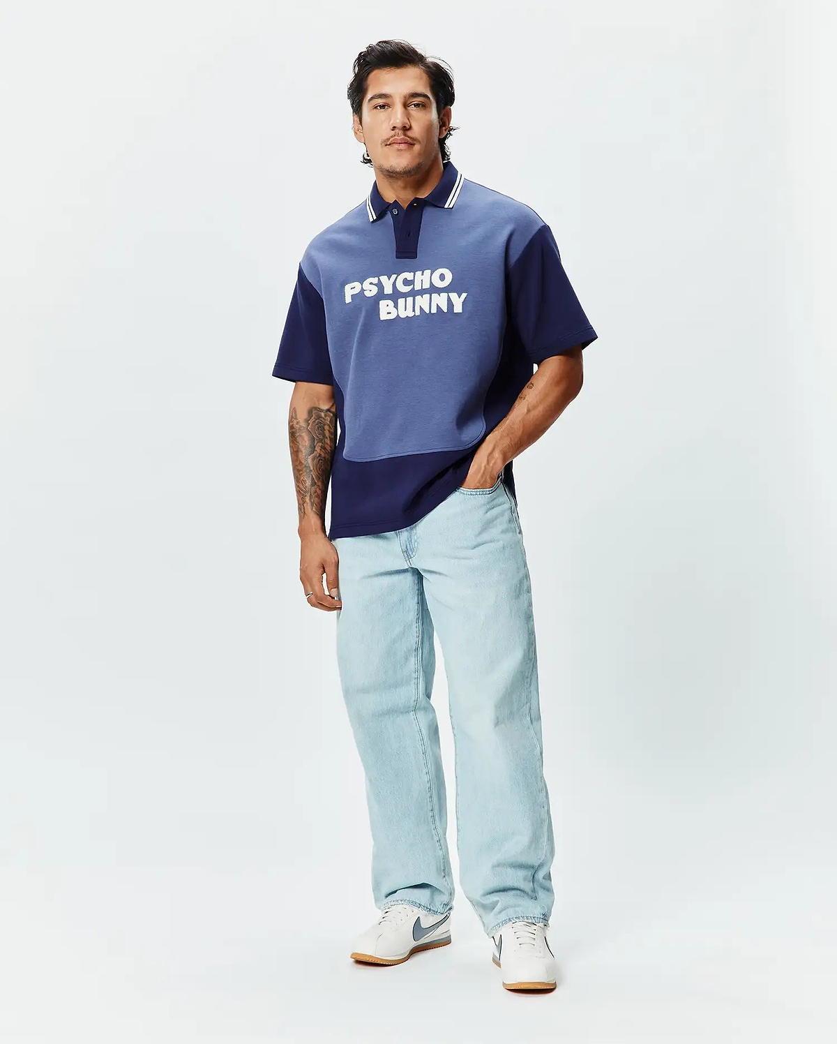 Mens Kelly Oversized Polo, a two-tone blue color block jersey polo with an oversized fit, featuring white collar stripes and a large white PSYCHO BUNNY text logo across the chest. (4)