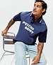 Mens Kelly Oversized Polo in two-tone navy blue soft jersey, featuring a classic collar with white stripes, a two-button placket, and a large white PSYCHO BUNNY text logo across the chest.