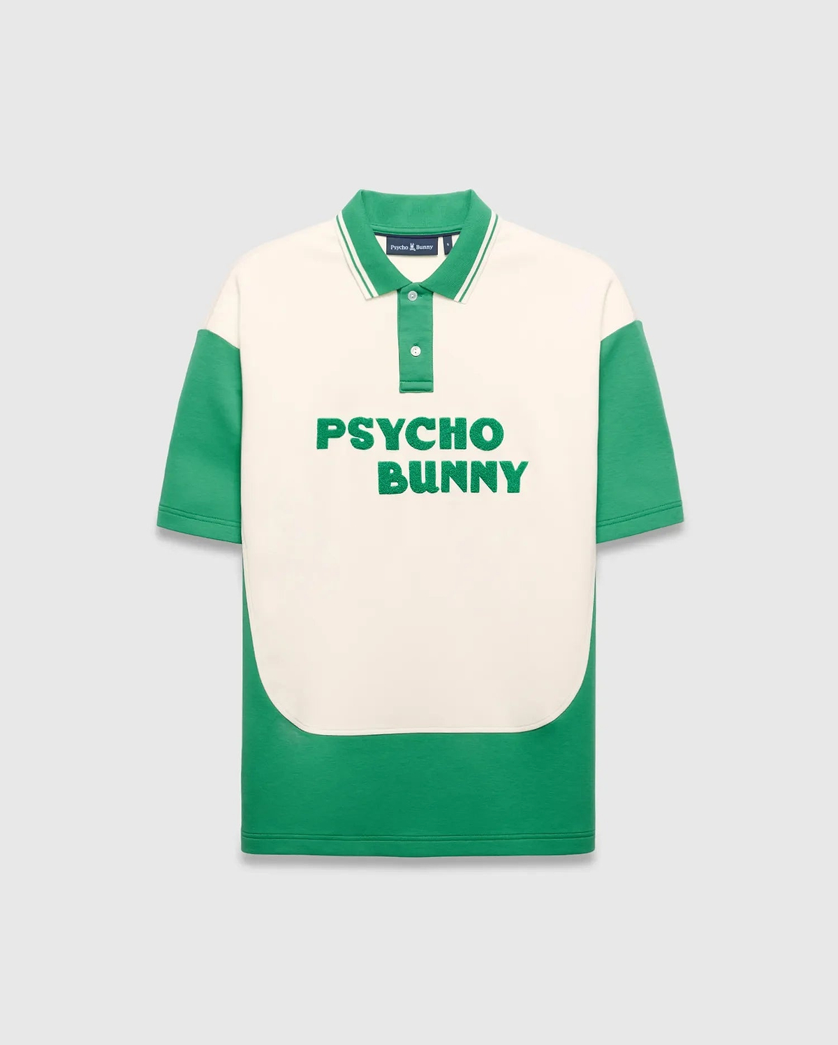 Mens Kelly Oversized Polo, cream and green color block smooth knit with large green PSYCHO BUNNY text on chest, ribbed collar with white stripes, and small embroidered bunny skull.