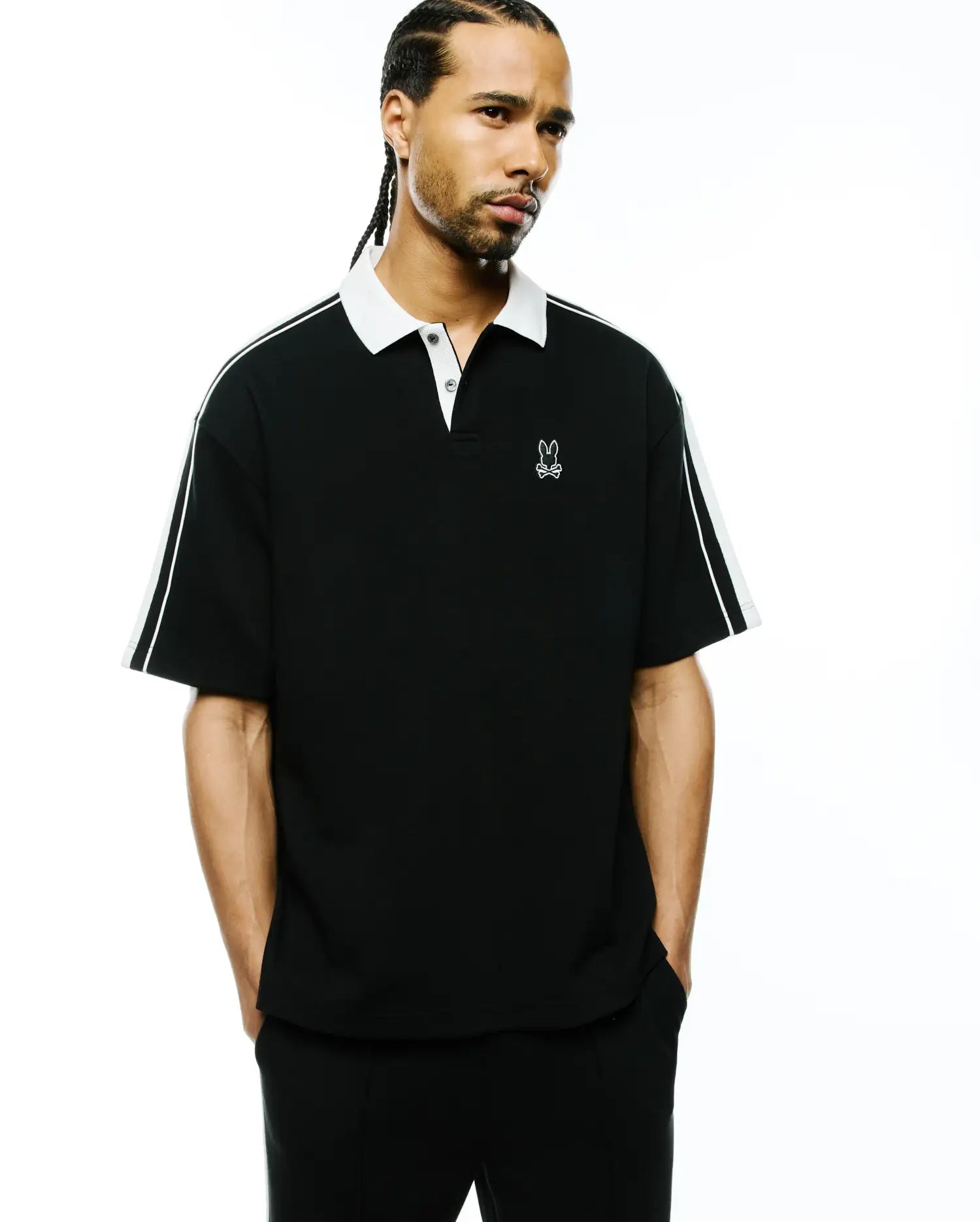 Mens Ceano Relaxed Fit Heavy Pique Polo, black with a crisp white collar, white double stripes on the sleeves, and a white embroidered Psycho Bunny skull logo on the left chest.