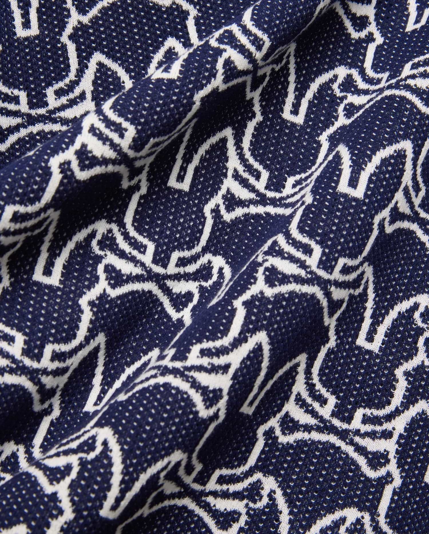 Mens Sidney Oversized Knit Polo in deep navy, featuring an all-over white outline Psycho Bunny skull logo pattern on a fine, textured knit fabric, offering a relaxed fit.