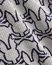 Mens Sidney Oversized Knit Polo in cream with an all-over navy blue Psycho Bunny skull logo pattern, featuring a distinctive open-weave knit texture. (5)