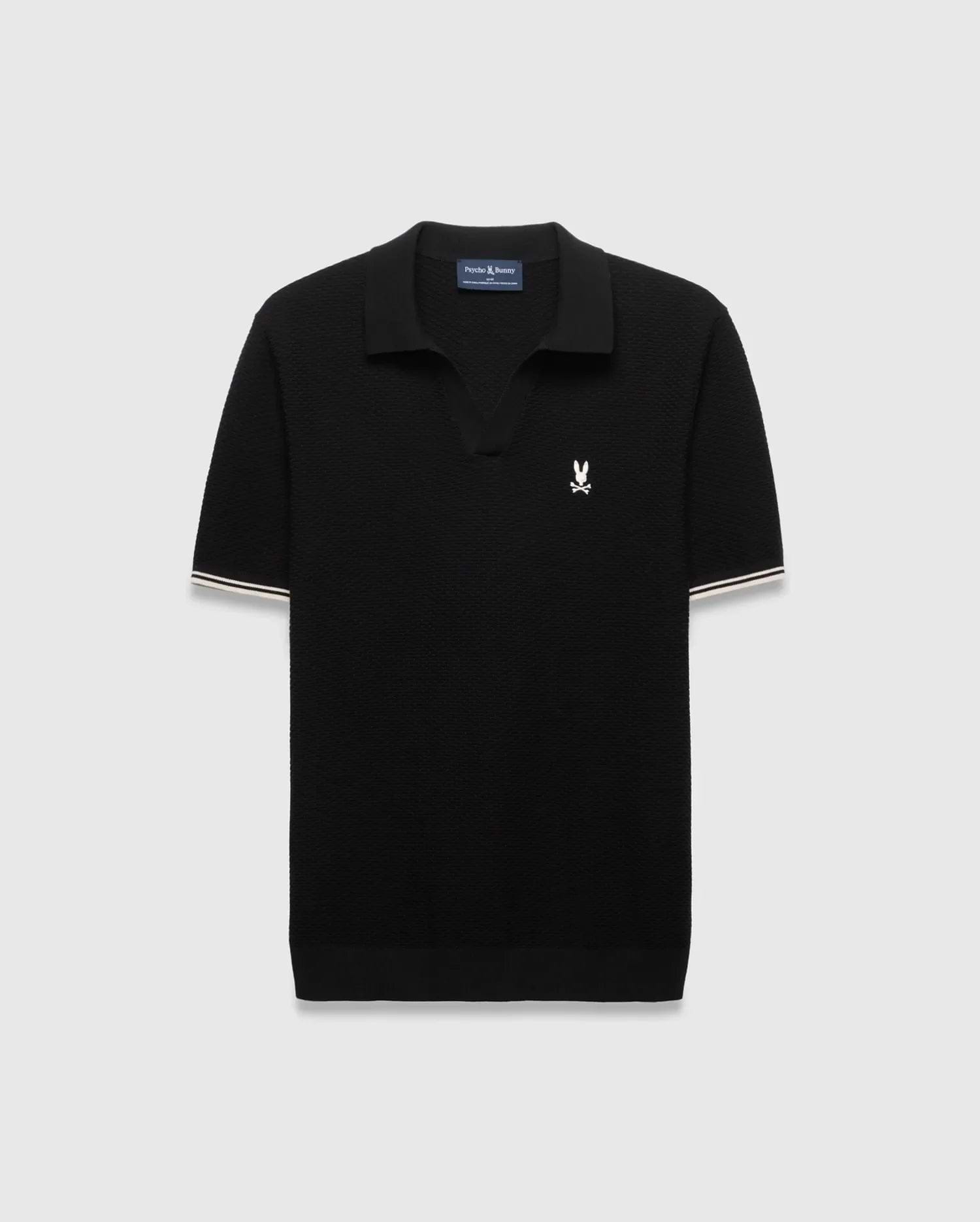 Black Mens Selby Knit Polo featuring a textured knit, classic fit, v-neck collar, and ribbed cuffs with white and cream double stripes. A small white embroidered Psycho Bunny skull logo adorns the left chest. (4)