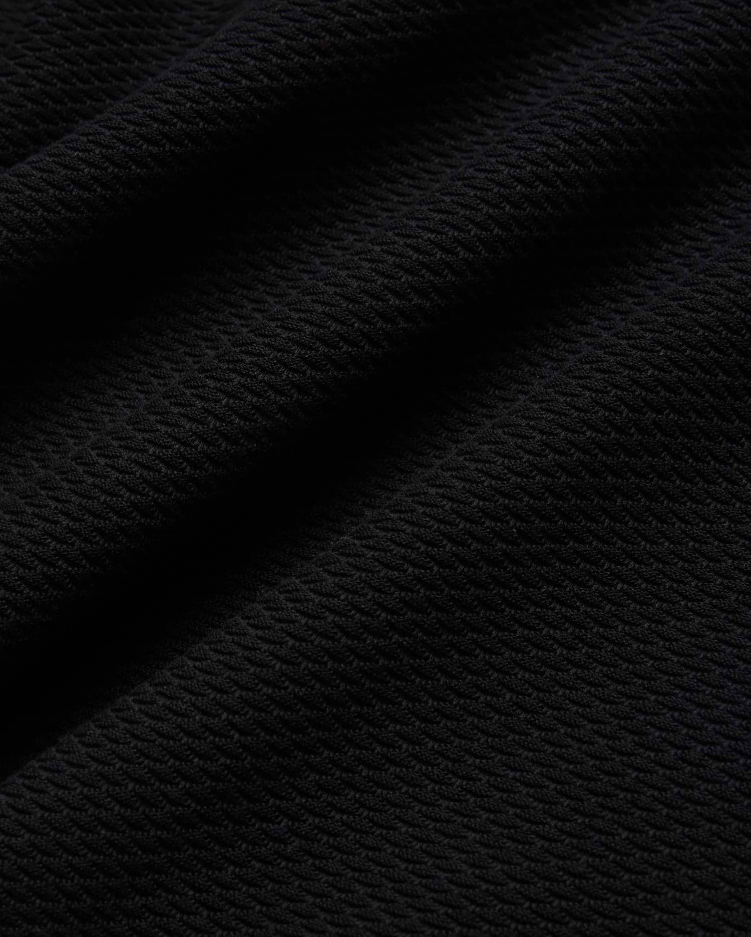 Mens Selby Knit Polo in deep black, showcasing a luxurious, finely textured knit fabric with a subtle, sophisticated diagonal pattern, ideal for refined streetwear. (5)