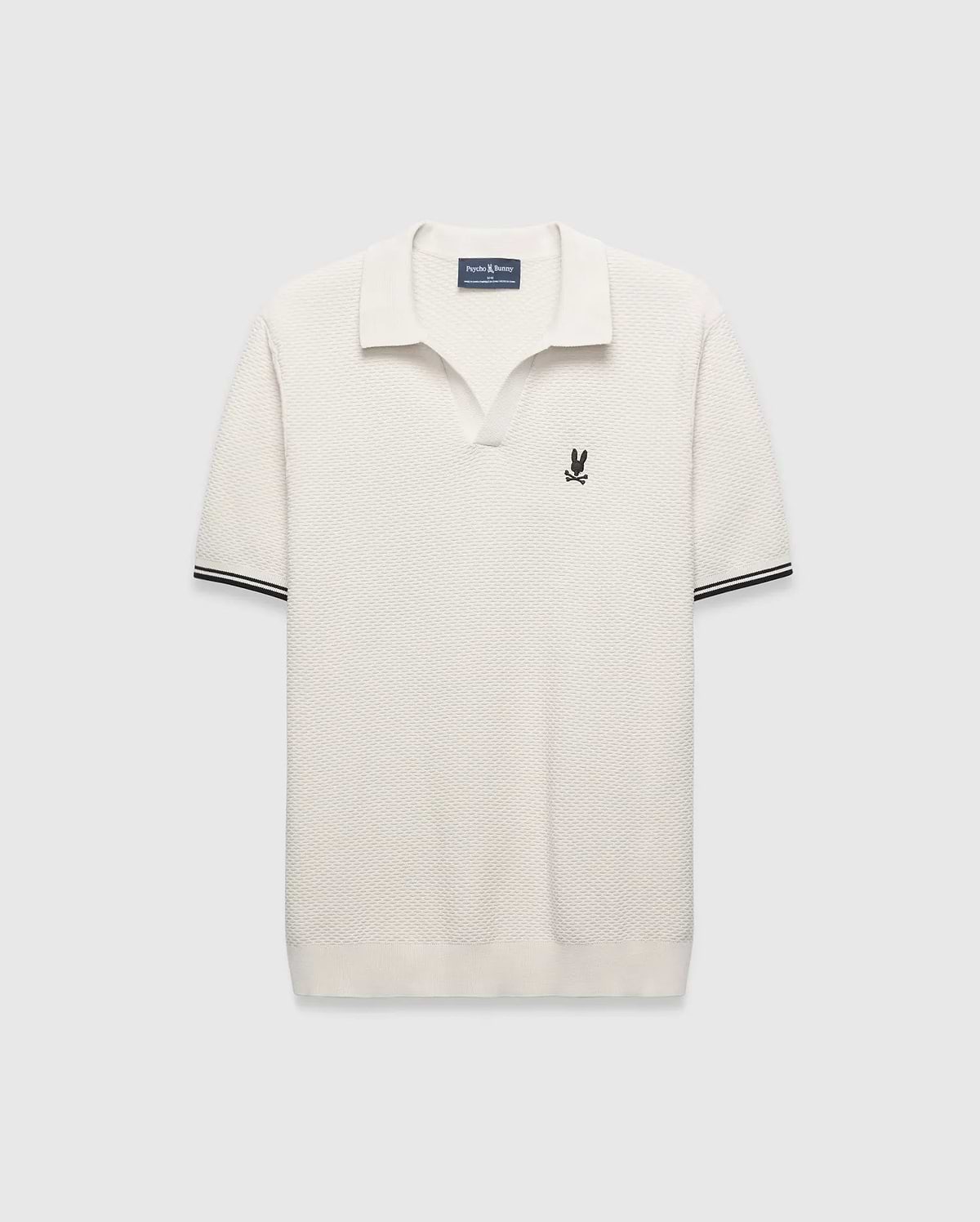 Cream Mens Selby Knit Polo featuring a unique textured knit fabric, open collar, small black embroidered Psycho Bunny skull logo on the left chest, and ribbed cuffs with black double stripes. (5)