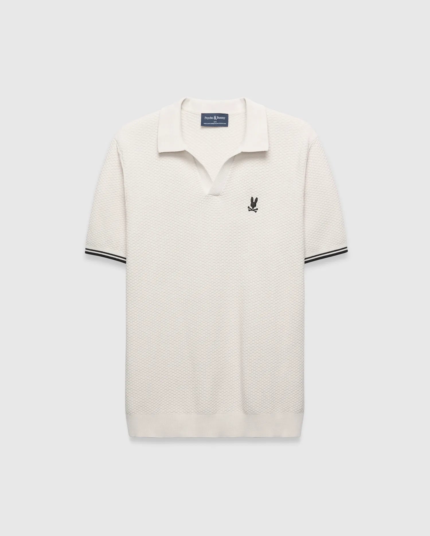 Cream Mens Selby Knit Polo featuring a unique textured knit fabric, open collar, small black embroidered Psycho Bunny skull logo on the left chest, and ribbed cuffs with black double stripes. (5)